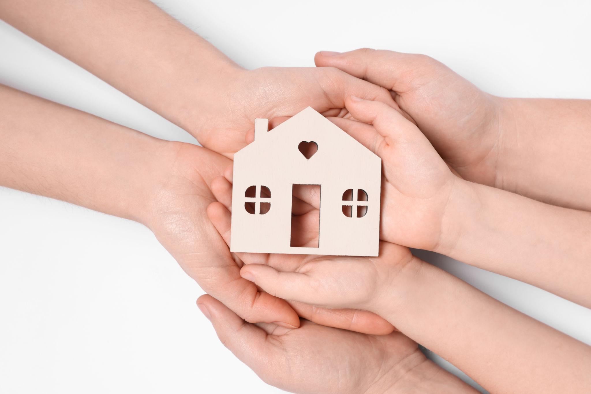 Manos sosteniendo una casa representando protección del hogar con seguro en Uruguay